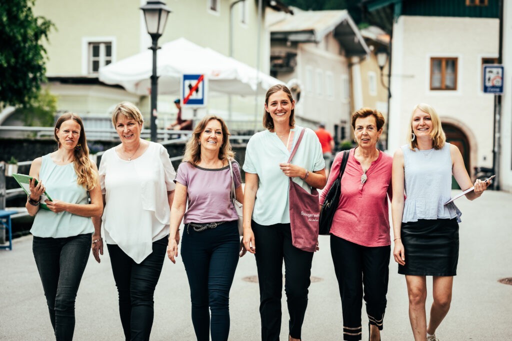 Mitarbeiterinnen von Springer Immobilien maschieren in der Metzergasse in Hallein für Gruppenfoto