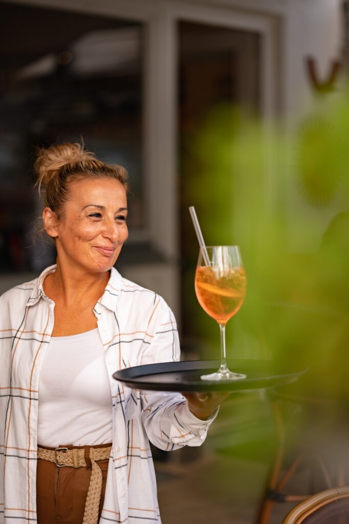 Kellnerin bei Cafe Sole in Hallein serviert Aperol Spritz