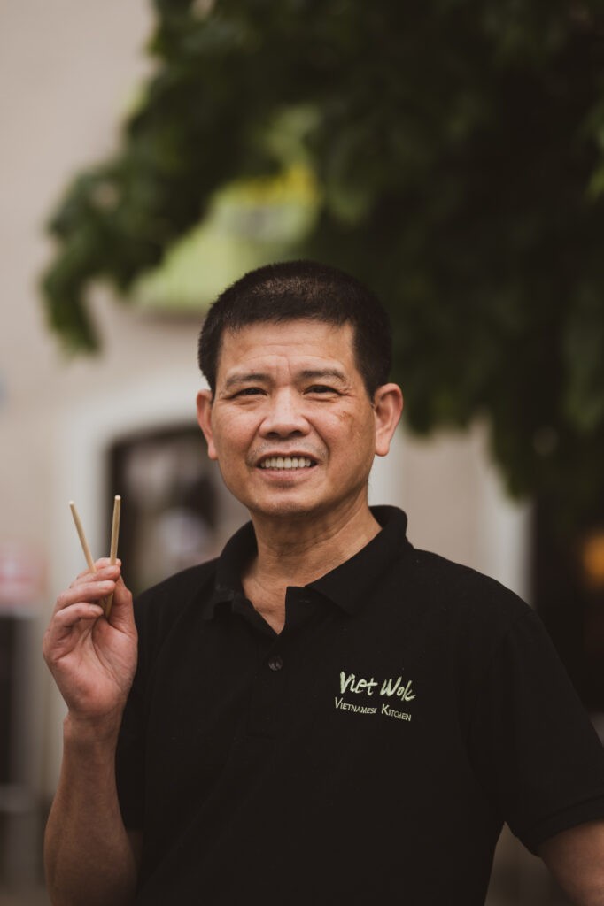 Portrait von Inhaber von Viet Wok Hallein mit Stäbchen in der Hand